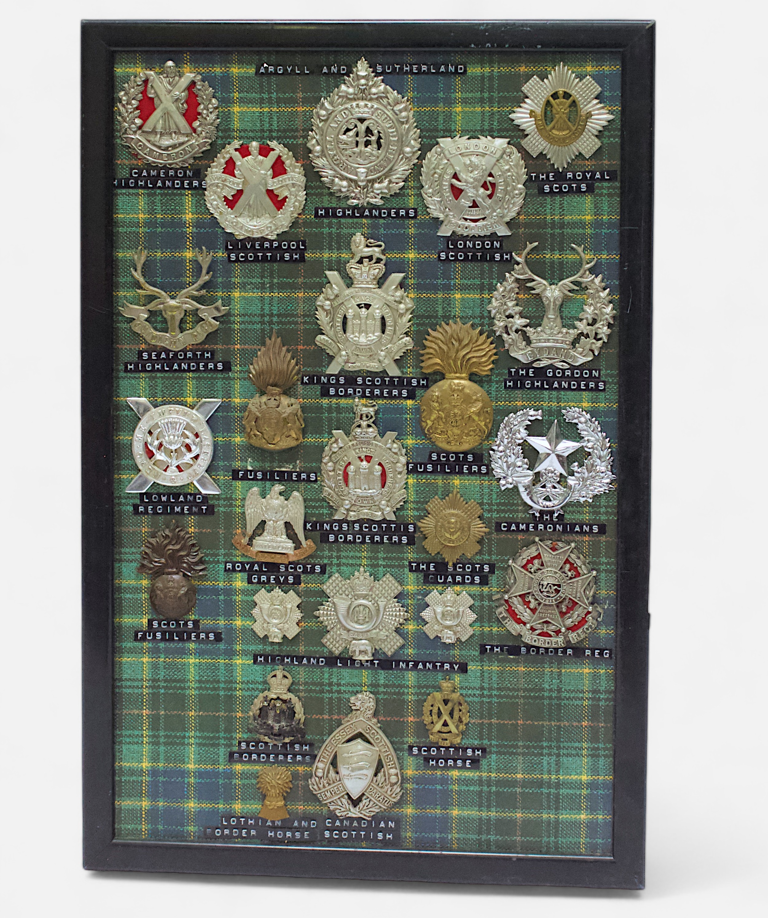Highland/Lowland/Scottish Regiment Cap Badges, twenty-four various, mounted on tartan backed