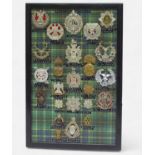 Highland/Lowland/Scottish Regiment Cap Badges, twenty-four various, mounted on tartan backed