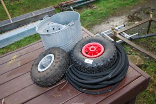 A quantity of wheels, tyres, roll of 5/16"rubber hose and a galvanised mop bucket.