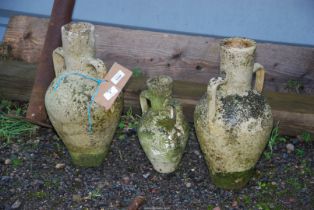 Three concrete urns; two large and one small.