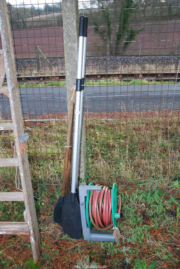 A hose on a reel and two pairs of oars/paddles.