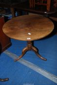 An Oak circular snap-top tavern table standing on a turned pillar with three splay feet,