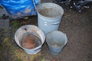 A galvanised dustbin, bath and large pail.