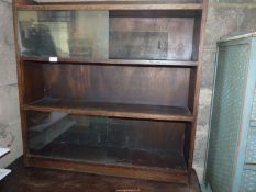 A wooden shelving unit with sliding top doors 3' wide x 8 1/2" x 3' high.