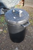 A plastic dustbin with lid.