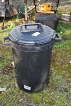 A plastic dustbin and lid.