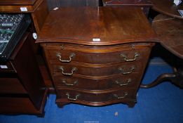 A serpentine fronted chest of four drawers with a pull-out brushing/folding slide,
