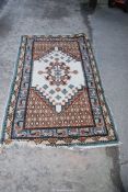 A bordered pattern and fringed rug in cream,blue brown and pink .42" wide x 72" long.