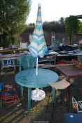 A round plastic table, three chairs, parasol and stool.