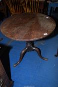 An Oak circular snap-top tavern table standing on a turned pillar with three splay feet,