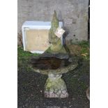 A scalloped edged bird bath with gnome, 34 1/2" high x 21" deep.