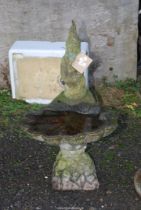 A scalloped edged bird bath with gnome, 34 1/2" high x 21" deep.