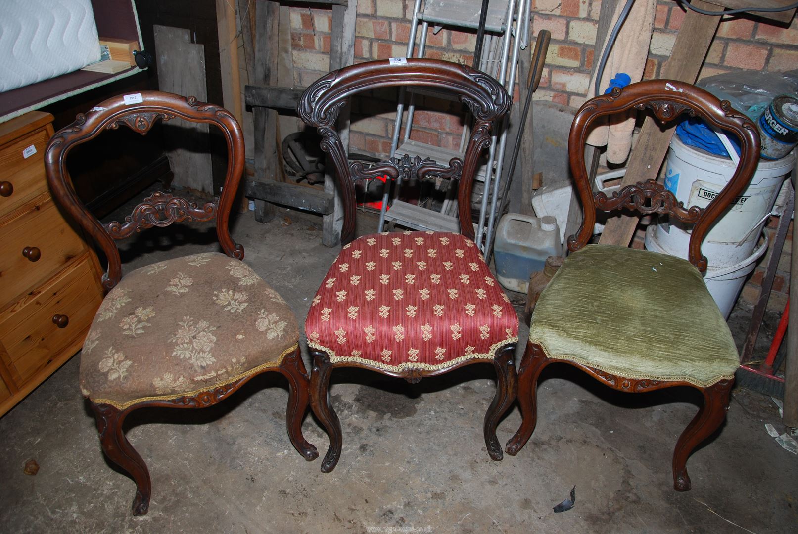 Three dining chairs with upholstered seats.