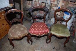 Three dining chairs with upholstered seats.