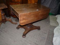 A 19th century Mahogany dropleaf centre Table standing on a turned and faceted tapering pillar with