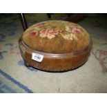 A low circular footstool.