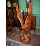 A very well portrayed carved wood sculpture of an Eagle perched on a domed base with its wings