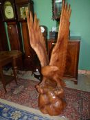 A very well portrayed carved wood sculpture of an Eagle perched on a domed base with its wings