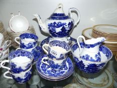 A vintage blue and white Willow pattern china tea service for six, with teapot,