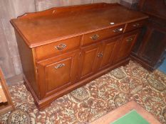 A contemporary darkwood possibly Cherrywood Sideboard having three frieze drawers over a cupboard