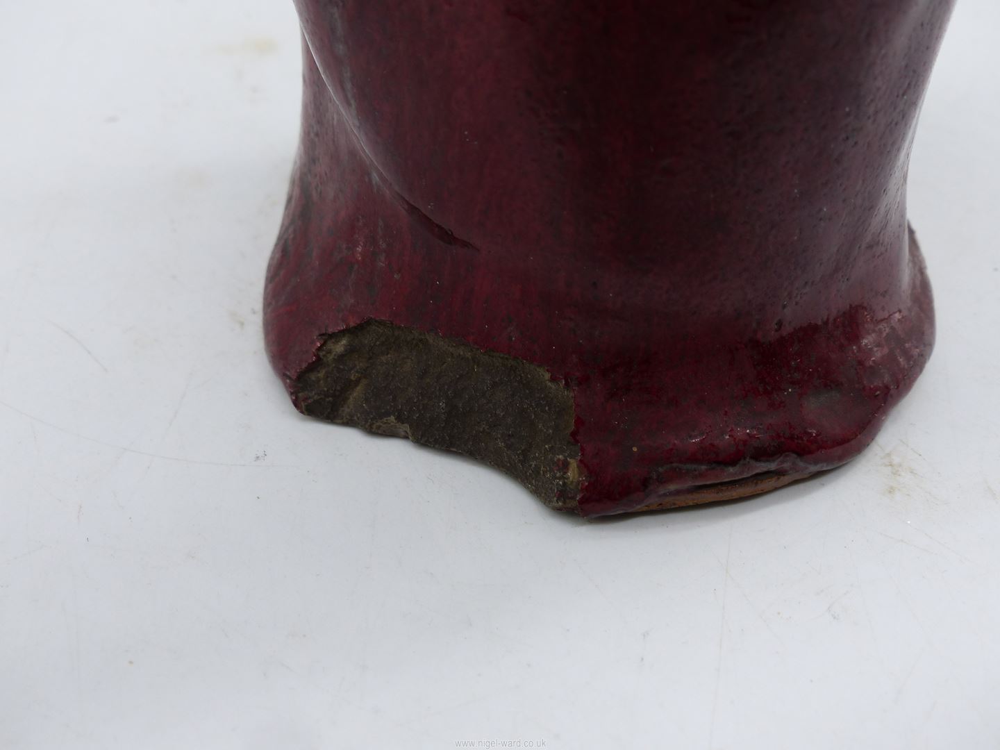 A Japanese red glazed stoneware figure of an Immortal holding a shoe, 11 1/4" tall. - Image 3 of 3