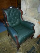 A dark Mahogany show framed low green upholstered wing Fireside Chair standing on scroll front legs