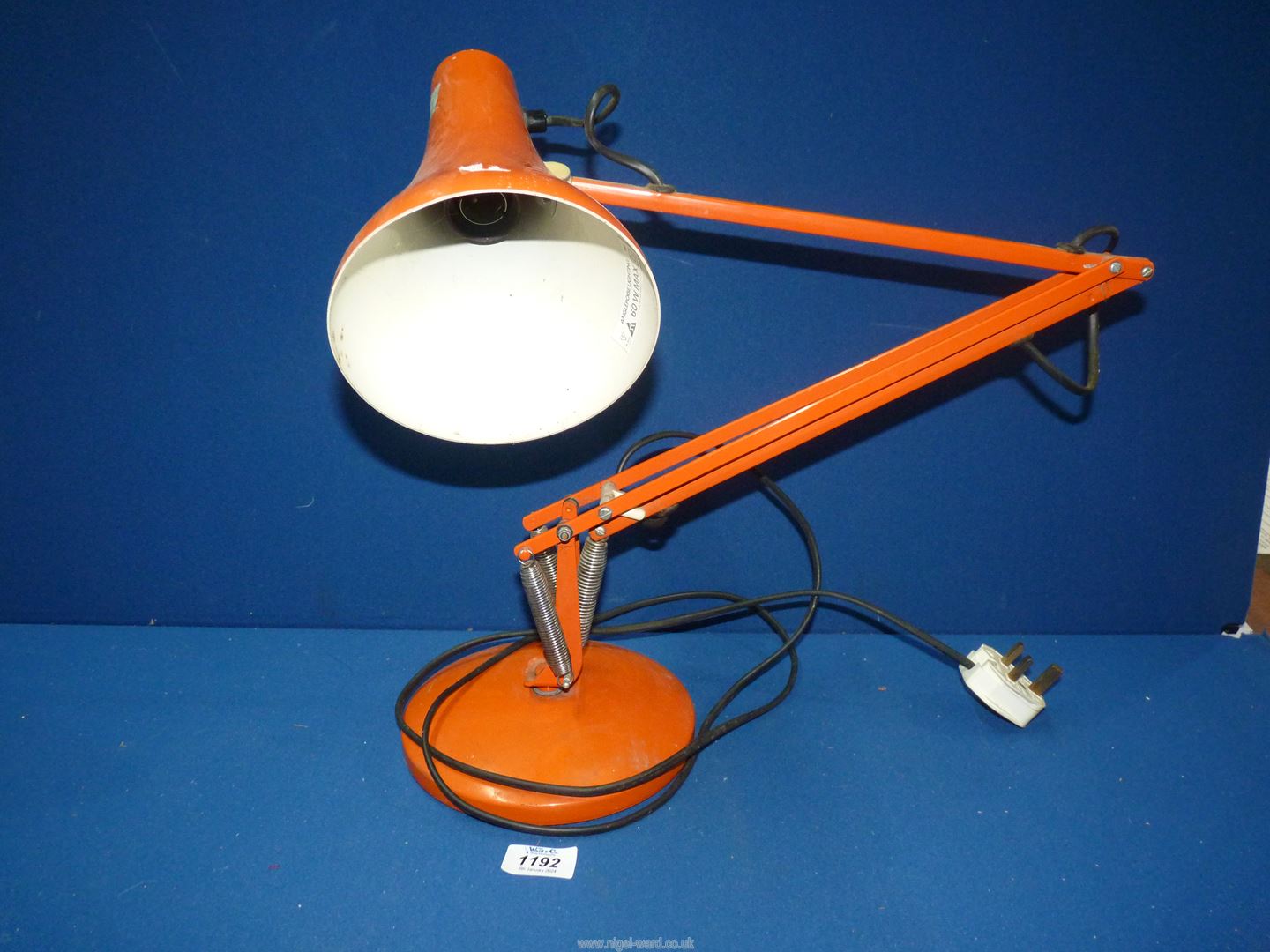 An orange angle poise lamp.