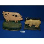 A cast metal Gloucester pig doorstop, 7" long and a Landrace pig doorstop, 6" long.