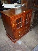 An Eastern hardwood Cabinet having a pair of four pane opposing glazed doors and with two long