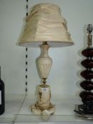 A white marble lamp base with brass details and cream shade, 26" tall.