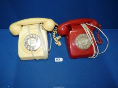 Two vintage rotary dial and corded Telephones, red and cream.