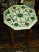 An octagonal occasional table standing on a Teak-wood type four legged base the top being of