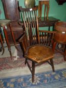 An arts and crafts hexagonal seated stickback Elbow Chair standing on turned legs and "H" stretcher,