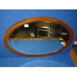 An Edwardiam Mahogany oval bevel plated Mirror with inlaid detail, 31 1/4'' x 22 1/2''.