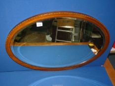 An Edwardiam Mahogany oval bevel plated Mirror with inlaid detail, 31 1/4'' x 22 1/2''.