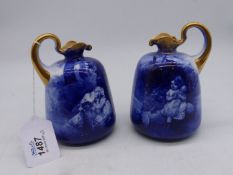 A pair of old Royal Doulton ewer vases in blue and white with two children under a tree and gilt