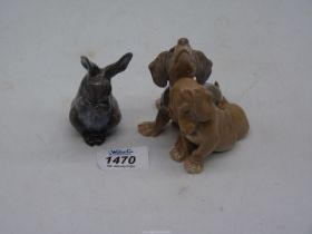 A small Copenhagen grey Rabbit eating a leaf and a B&G Denmark figure of two brown Dachshund.