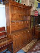 A medium Oak Dresser, the base with three double panel doors with three frieze drawers over,