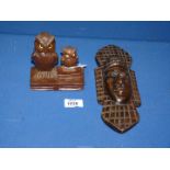 An early 20th century Black Forest carving of two owls perched on books, both with glass eyes,