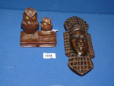 An early 20th century Black Forest carving of two owls perched on books, both with glass eyes,