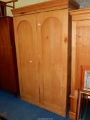 A Pine double wardrobe/compactum with shelves to one side, arch doored,