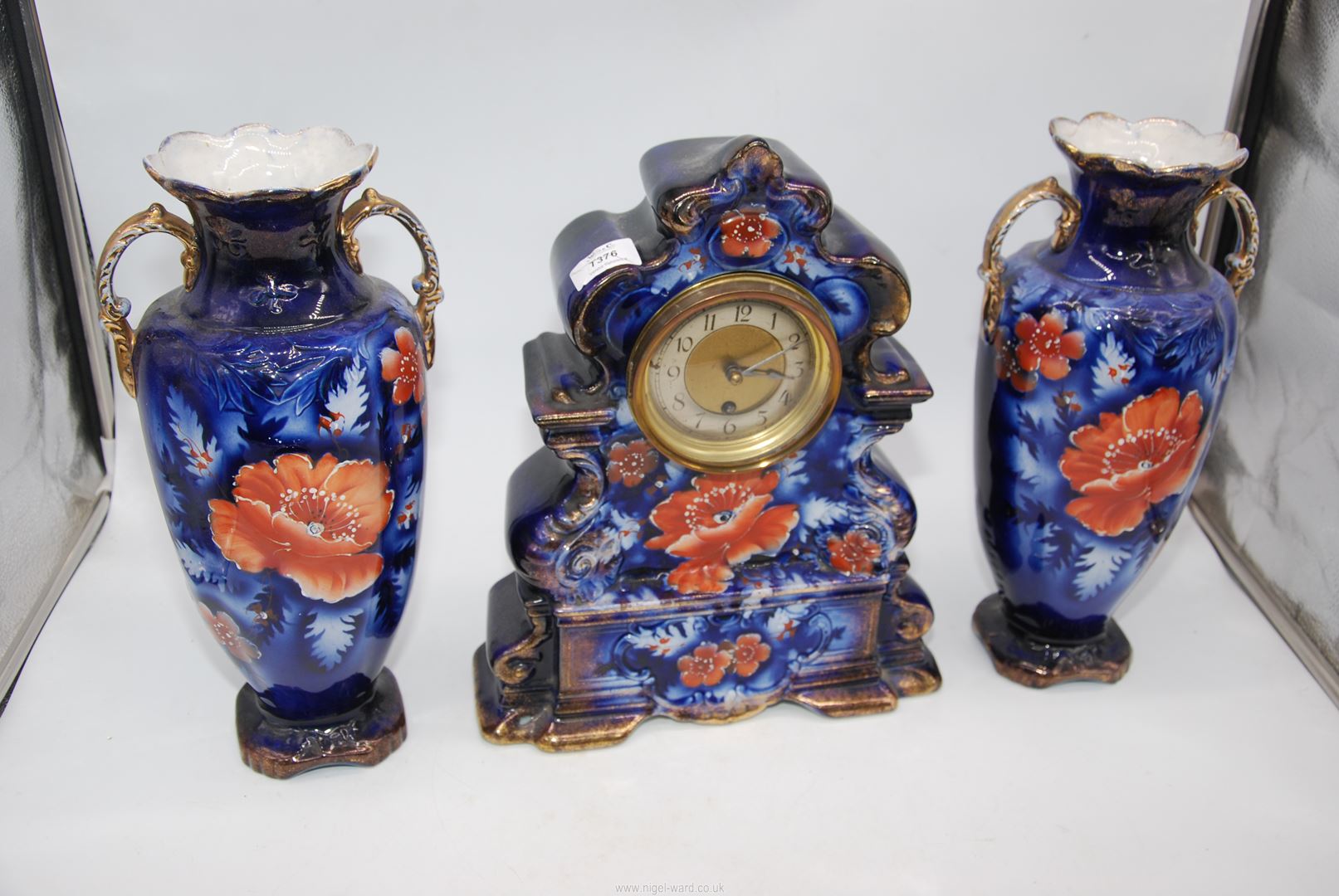 An elegant porcelain Clock Garniture decorated with dusky pink Chrysanthemum type flower blooms