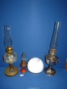 Three oil lamps including clear glass reservoir with brass base,