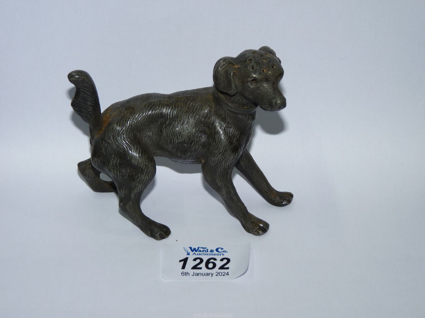 An unusual cast metal pepper pot in the form of a dog, 3 1/4" high x 5" long.