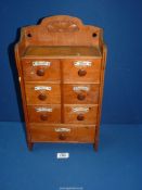 A small seven drawer spice/herb Cabinet with china plaques, 9 1/4" x 17" high x 4" deep.