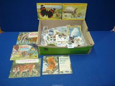 A box of animal related cigarette cards and postcards.