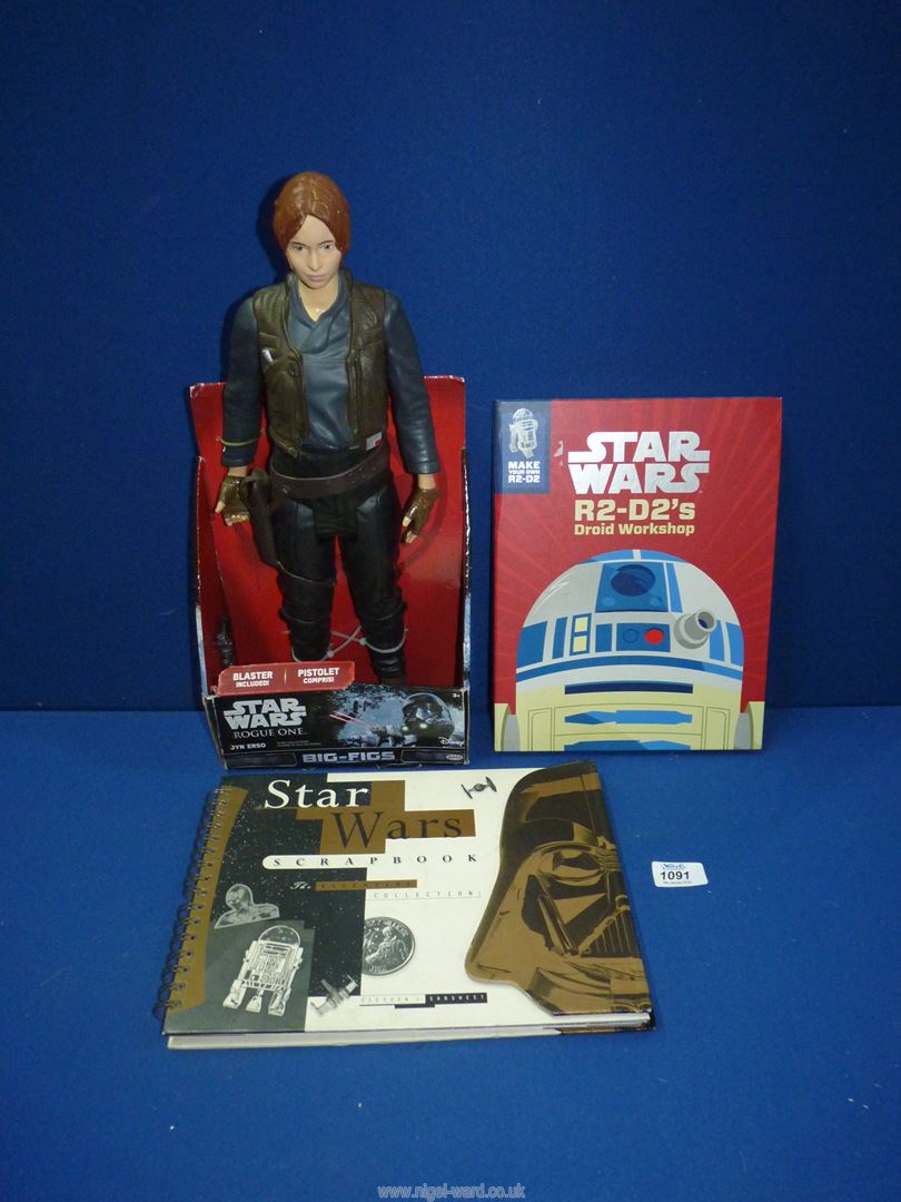 A large Jyn Erso Star Wars figure and two Star Wars collectors books.