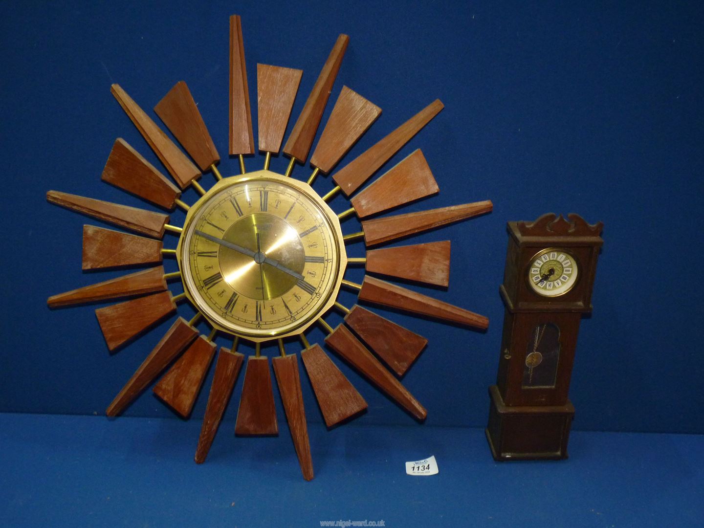 An Anstey Wilson battery Sunburst wall clock and a Mercedes clock in the form of a miniature