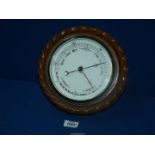 A circular oak framed aneroid Barometer with carved rope surround, 9 1/2'' diameter.