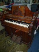 A mixed woods 4 1/2 octave Harmonium of arts and craft design with fretwork decoration,